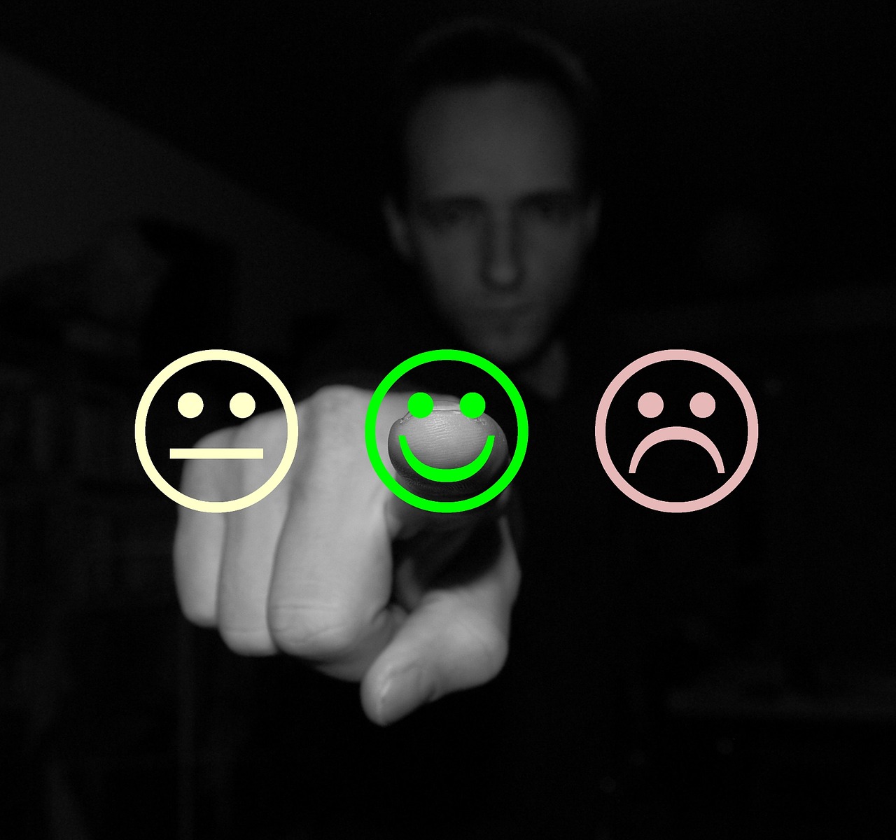 Zeigefinger vor drei Smileys, die für drei Bewertungen stehen: gut, mittel, schlecht